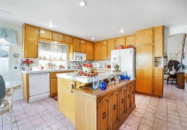 1308 Pleasant Valley Ave, Banning, CA 92220 - kitchen with a center island, white appliances, light countertops, and light tile patterned flooring