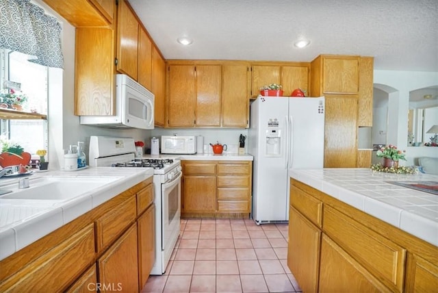 1308 Pleasant Valley Ave, Banning, CA 92220 - kitchen featuring white appliances, brown cabinets, tile countertops, and light tile patterned flooring