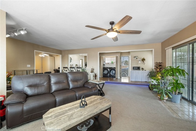 living room featuring ceiling fan, washing machine and dryer, and light carpet