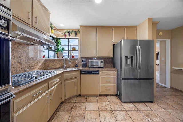 kitchen with tasteful backsplash, appliances with stainless steel finishes, sink, and light stone counters