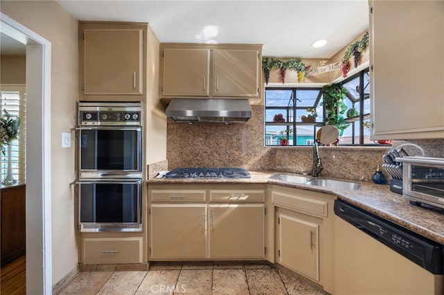 kitchen featuring appliances with stainless steel finishes, tasteful backsplash, sink, exhaust hood, and cream cabinets