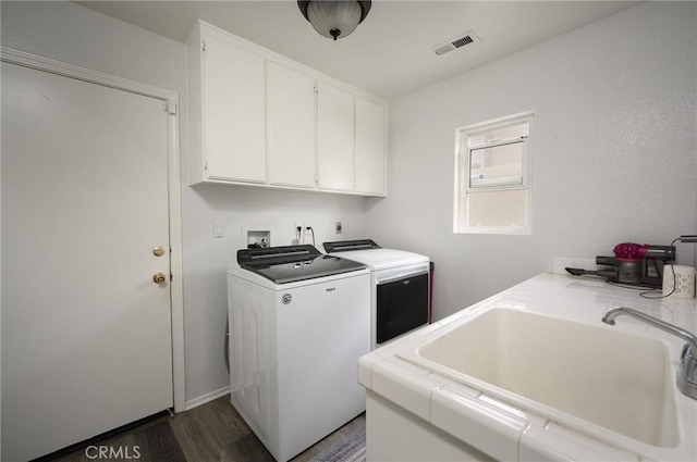 laundry area with cabinets, sink, dark wood-type flooring, and washer and clothes dryer