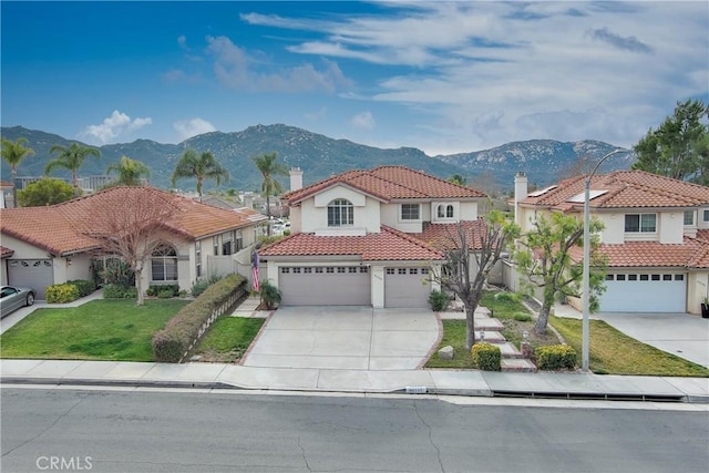 mediterranean / spanish-style house featuring a garage, a mountain view, and a front yard