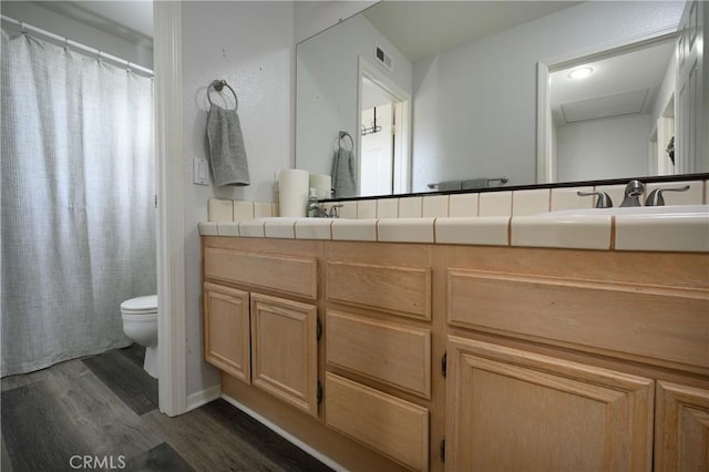 bathroom with wood-type flooring, toilet, and vanity