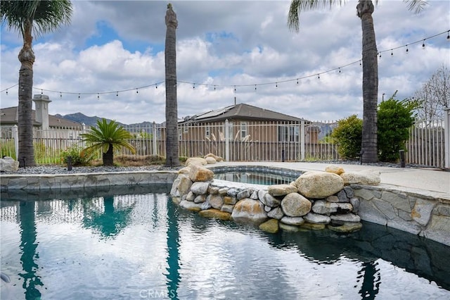 view of pool with an in ground hot tub