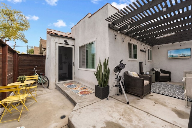 back of property featuring a pergola, a fenced backyard, stucco siding, a patio area, and a tiled roof
