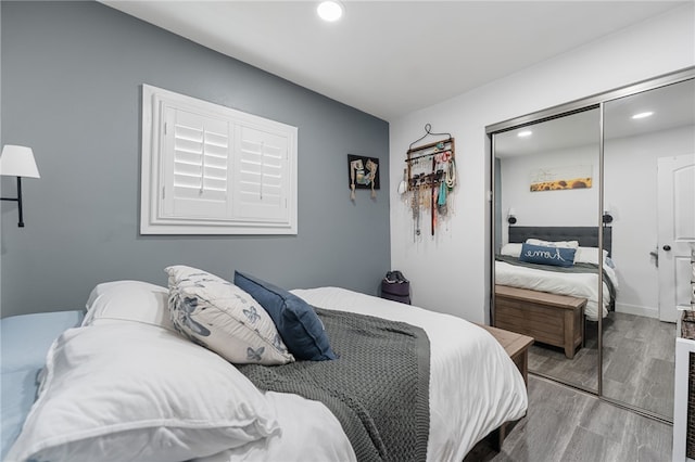 bedroom featuring recessed lighting, wood finished floors, and a closet