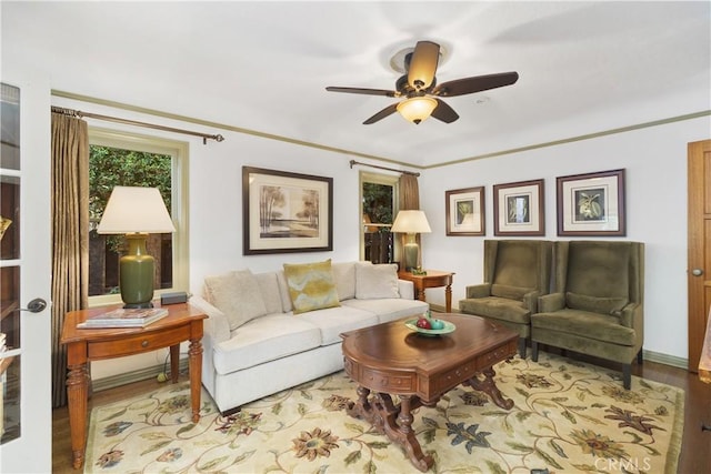 living room with light hardwood / wood-style flooring, ornamental molding, and ceiling fan