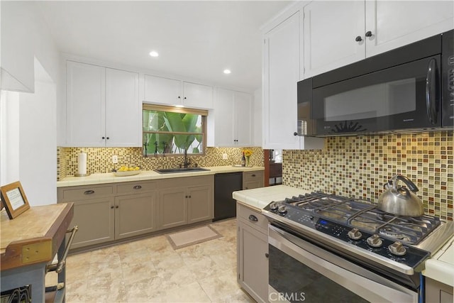 kitchen featuring tasteful backsplash, white cabinets, sink, and black appliances