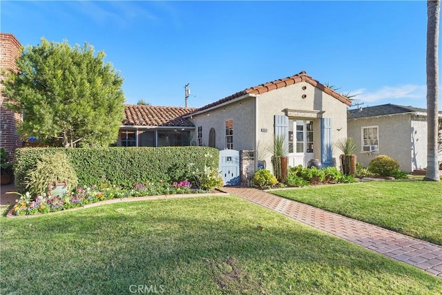 mediterranean / spanish-style home featuring a front yard