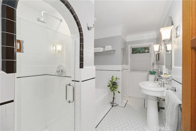 bathroom featuring tile patterned flooring, tile walls, and an enclosed shower