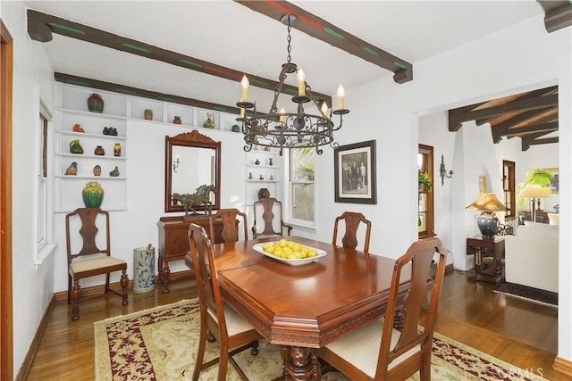 dining room with wood-type flooring, a chandelier, and beamed ceiling