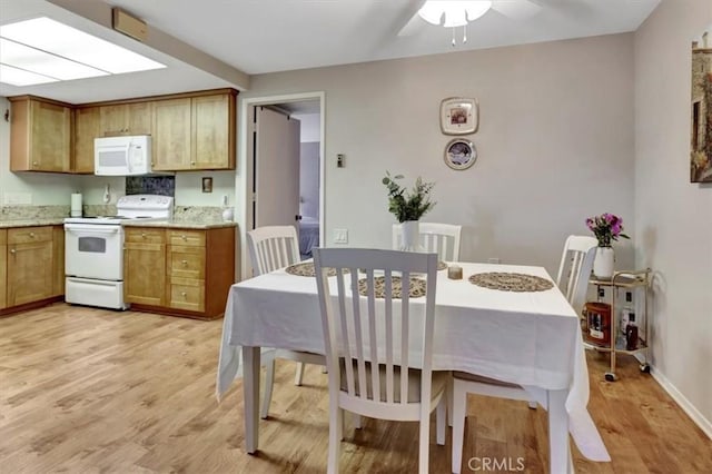 kitchen with ceiling fan, white appliances, and light hardwood / wood-style flooring