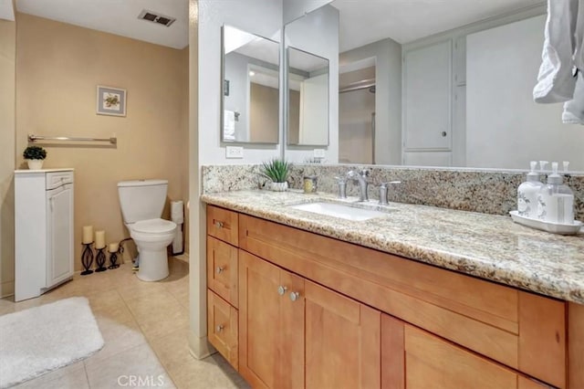 bathroom with vanity, toilet, and tile patterned flooring