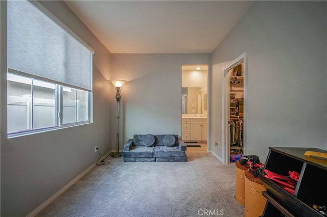 living area with light carpet and baseboards