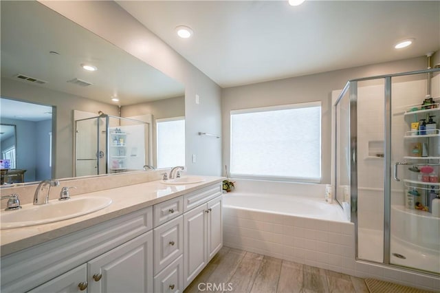 full bath with a stall shower, visible vents, a sink, and double vanity