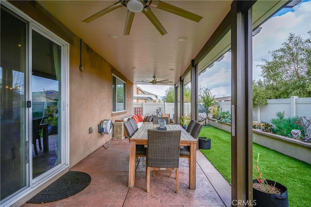 view of patio with ceiling fan, outdoor dining area, and a fenced backyard