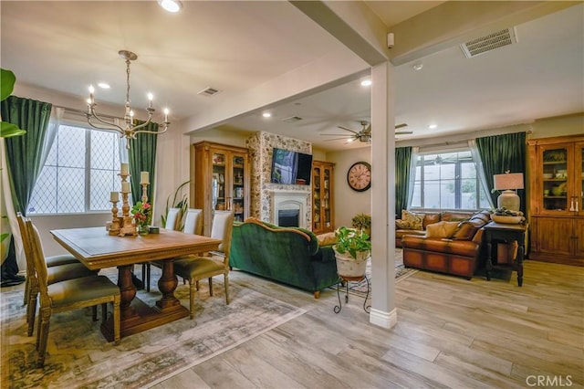 dining space featuring light wood-style flooring, a fireplace, visible vents, and recessed lighting