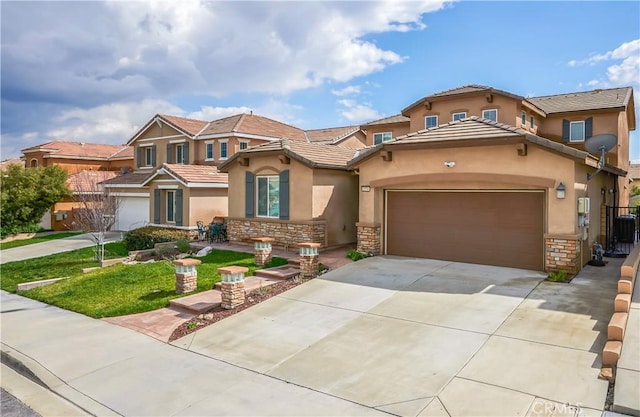 mediterranean / spanish-style home with an attached garage, stone siding, driveway, and stucco siding