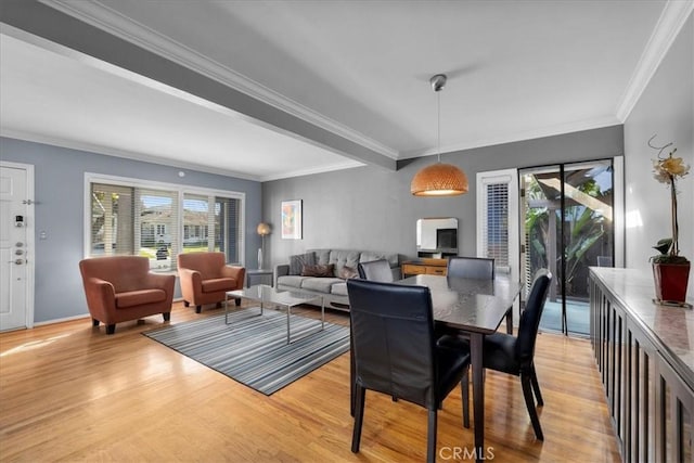 dining room with ornamental molding, light hardwood / wood-style floors, and a healthy amount of sunlight