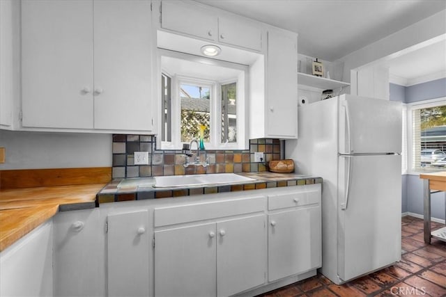 kitchen featuring sink, white cabinetry, tile counters, decorative backsplash, and white fridge