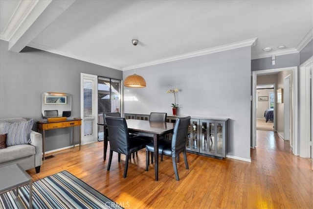 dining space featuring crown molding and light hardwood / wood-style flooring