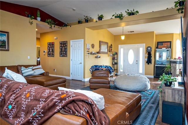 living area with visible vents, wood finished floors, baseboards, and vaulted ceiling