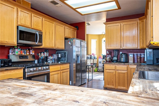 kitchen with light countertops, wood finished floors, visible vents, and appliances with stainless steel finishes