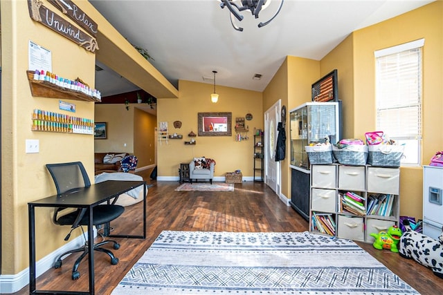 office featuring lofted ceiling, wood finished floors, baseboards, and visible vents