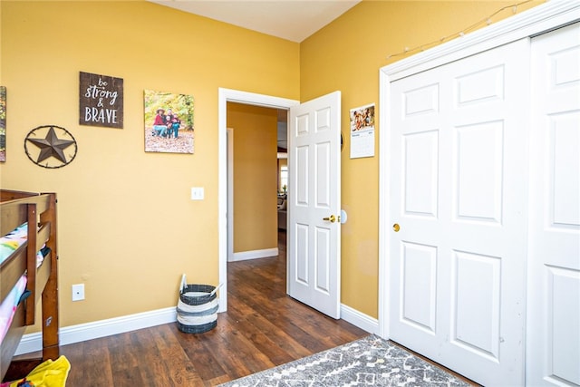 bedroom featuring a closet, baseboards, and wood finished floors