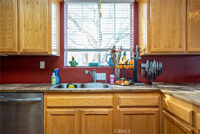 kitchen with a sink, dishwasher, and a textured wall