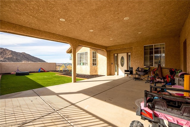 view of patio with a mountain view and fence