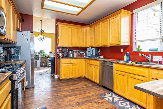 74384 Rocky Rd Unit 29, Palms, CA 92277 - kitchen with stainless steel appliances, a sink, dark wood-style flooring, hanging light fixtures, and a chandelier