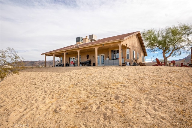 back of property featuring french doors and stucco siding