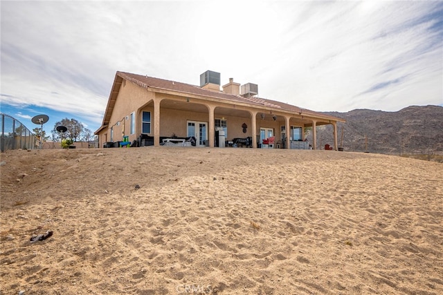 74384 Rocky Rd Unit 29, Palms, CA 92277 - back of house featuring a chimney, a mountain view, and stucco siding