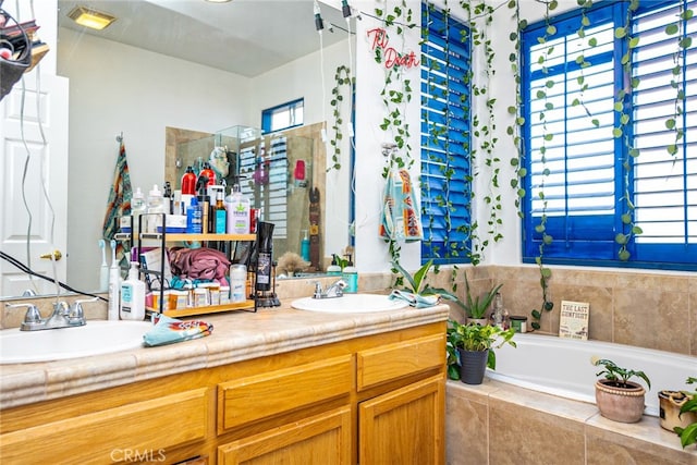 bathroom featuring a sink, a bath, and double vanity