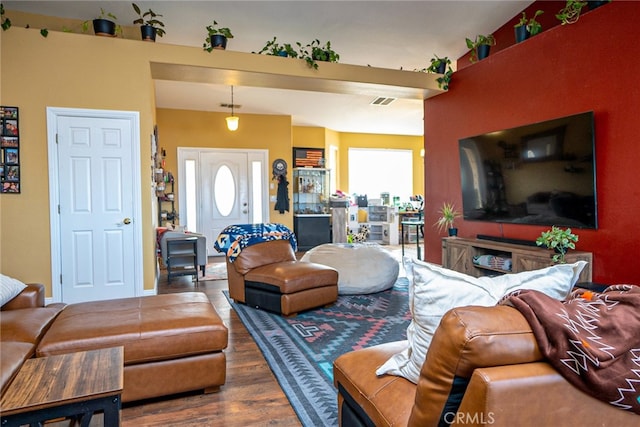 living area with visible vents and wood finished floors