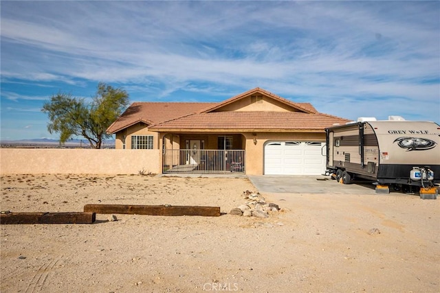 74384 Rocky Rd Unit 29, Palms, CA 92277 - ranch-style home with an attached garage, dirt driveway, fence, stucco siding, and a tiled roof
