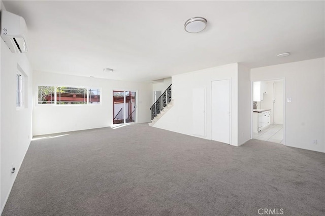 unfurnished room featuring an AC wall unit and light carpet