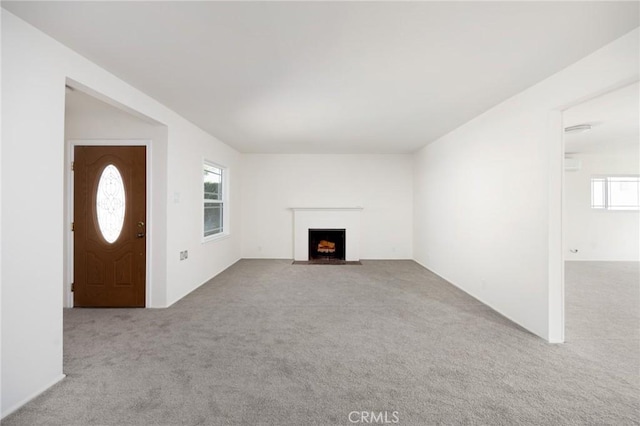 unfurnished living room featuring light carpet