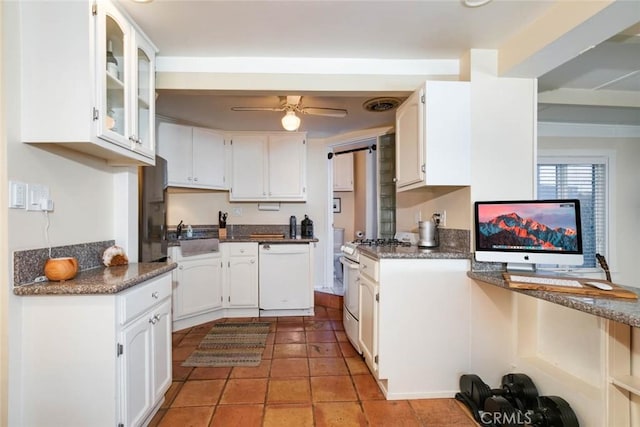 kitchen featuring stainless steel gas range oven, dishwasher, dark stone counters, and white cabinets