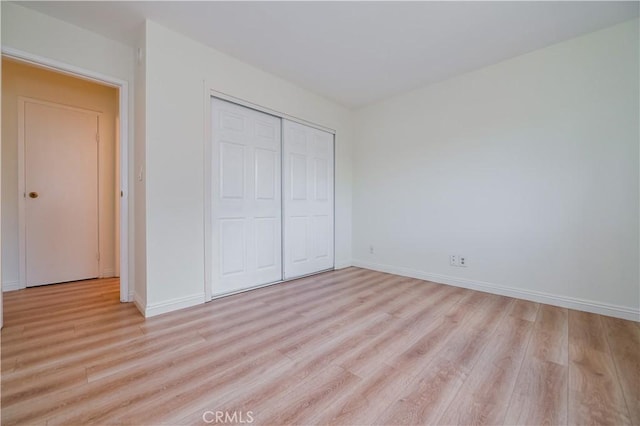 unfurnished bedroom featuring a closet and light wood-type flooring