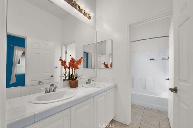 bathroom featuring double vanity, tile patterned floors, a sink, and shower / bathing tub combination