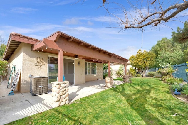back of house with a ceiling fan, a fenced backyard, a yard, a patio, and stucco siding