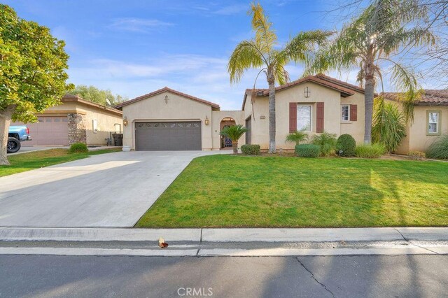 mediterranean / spanish-style house with concrete driveway, stucco siding, an attached garage, and a front yard