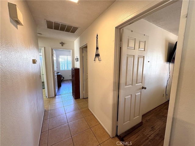 hallway with light tile patterned flooring and visible vents