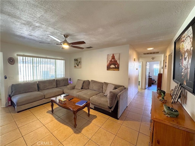 tiled living room with ceiling fan and a textured ceiling