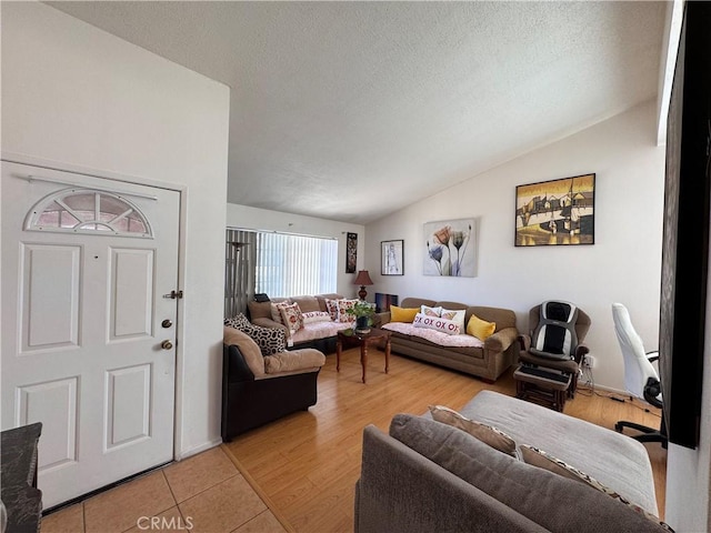 tiled living room with vaulted ceiling and a textured ceiling