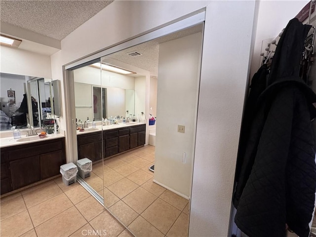 bathroom with vanity, tile patterned flooring, and a textured ceiling