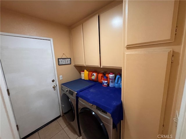 washroom with cabinets, washing machine and dryer, and light tile patterned floors